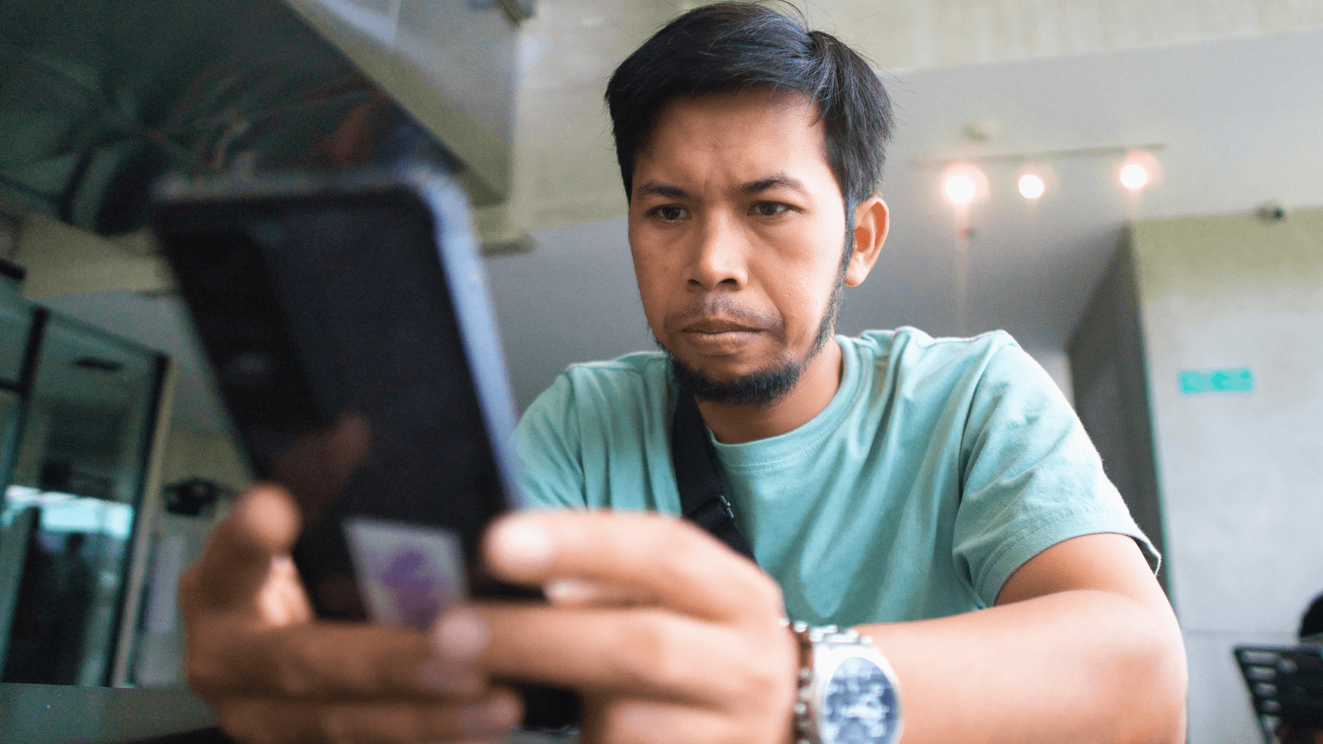 Seorang lelaki menggunakan telefon pintar ketika berita dalam talian dan kemas kini media sosial tersebar di sekelilingnya.